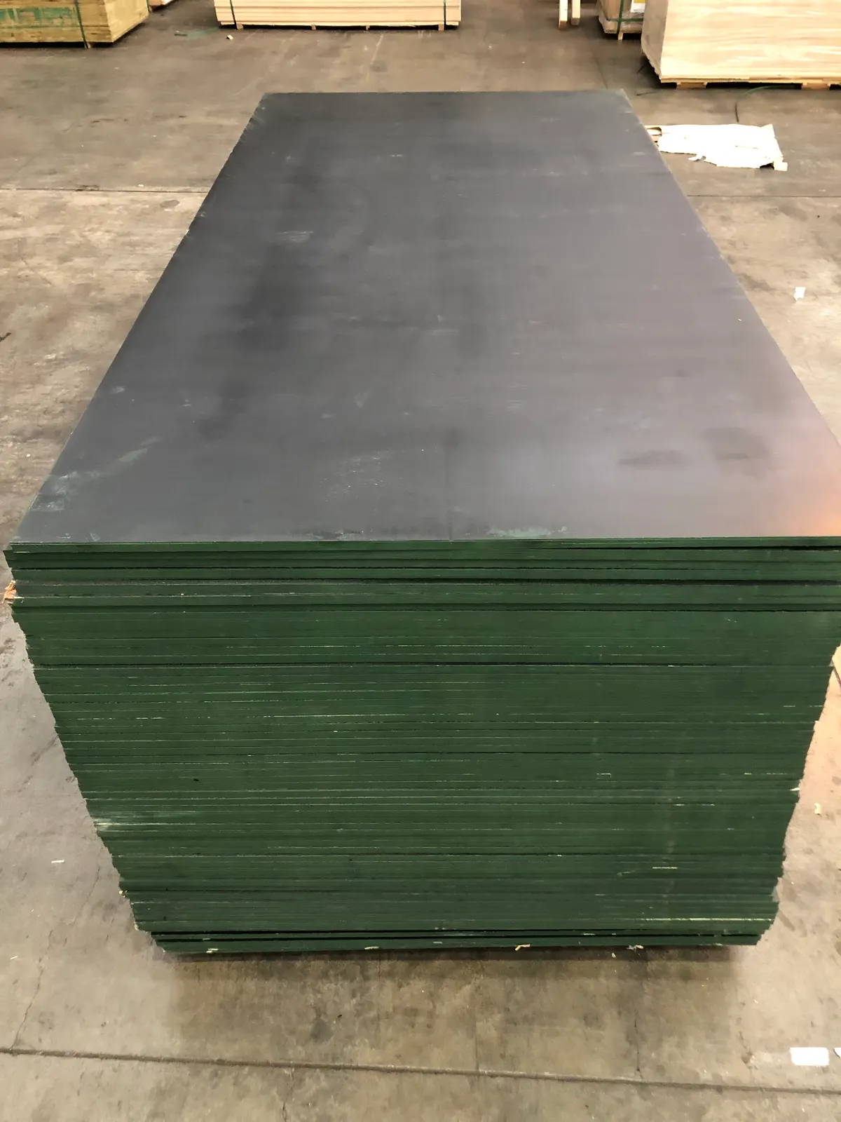 Tall stack of black film-faced formply sheets